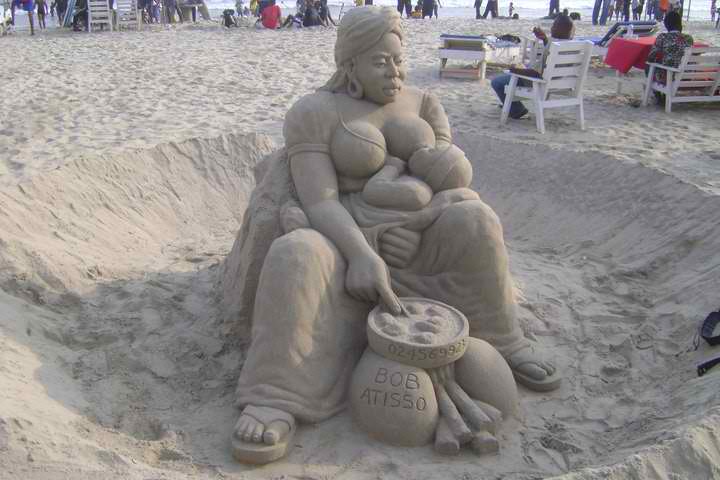 Photo d'une sculpture de sable réalisée par Bob Atisso : maman et bébé en plein allaitement maternel